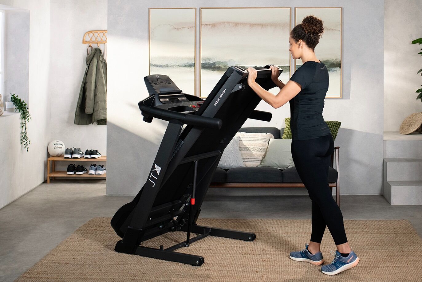 Woman Folding JTX Fitness Sprint 7 Treadmill