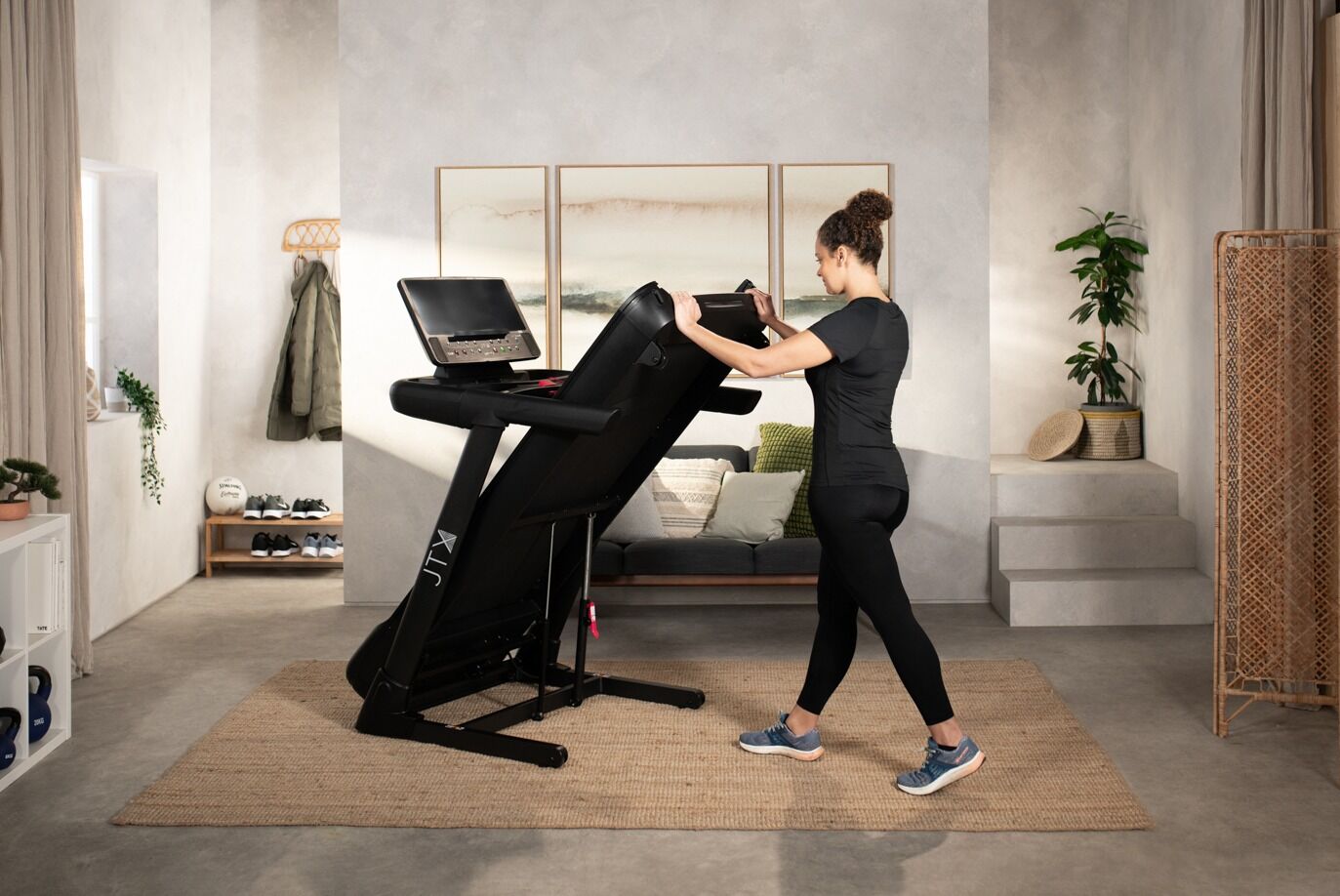 Woman folding up the deck on JTX Sprint 8 treadmill