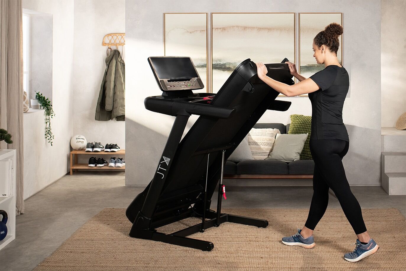 Woman folding up the deck on JTX Sprint-8 Pro treadmill