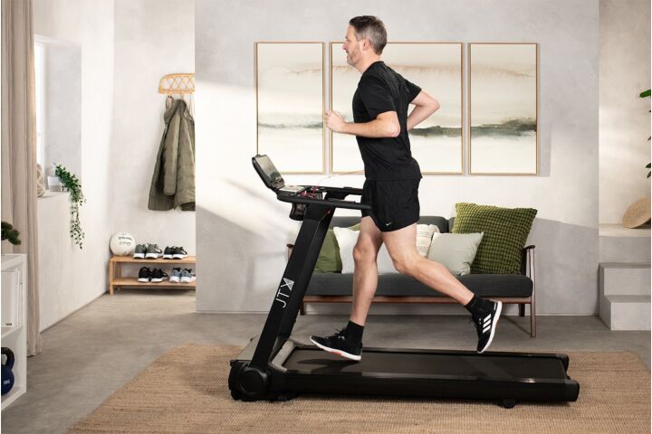 JTX Fitness Runrise XL flat folding treadmill with man running on it